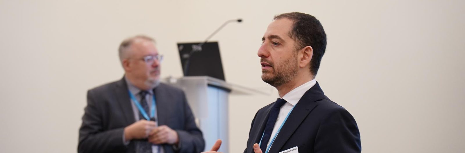 Panos Panagiotakopoulos presenting, with Kent Peel at the podium behind him